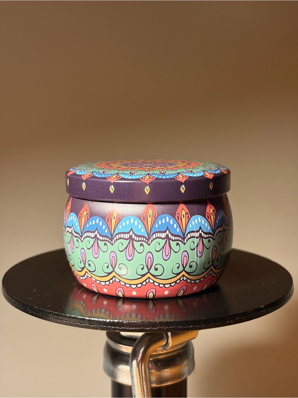 Colorful metal tin container features intricate mandala patterns.